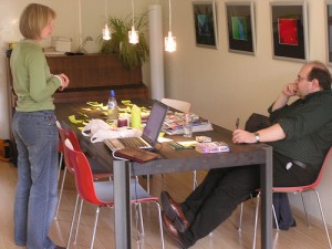 Content vs conversation. A photograph of a sitting man and a standing woman talking with each other, a crowded table between them.  Image attribution: http://www.flickr.com/photos/tonz/ / CC BY-NC-SA 2.0