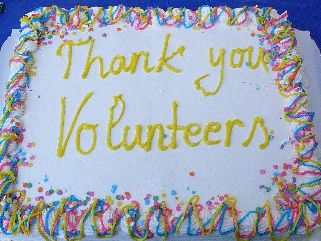 Using volunteers at conferences: a photo of a rectangular iced cake with "Thank your Volunteers" written on the top in yellow icing.