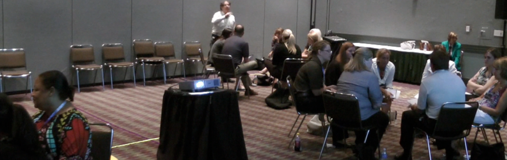 power of experiential learning: photograph of Adrian Segar facilitating a workshop with participants seated in circles of chairs