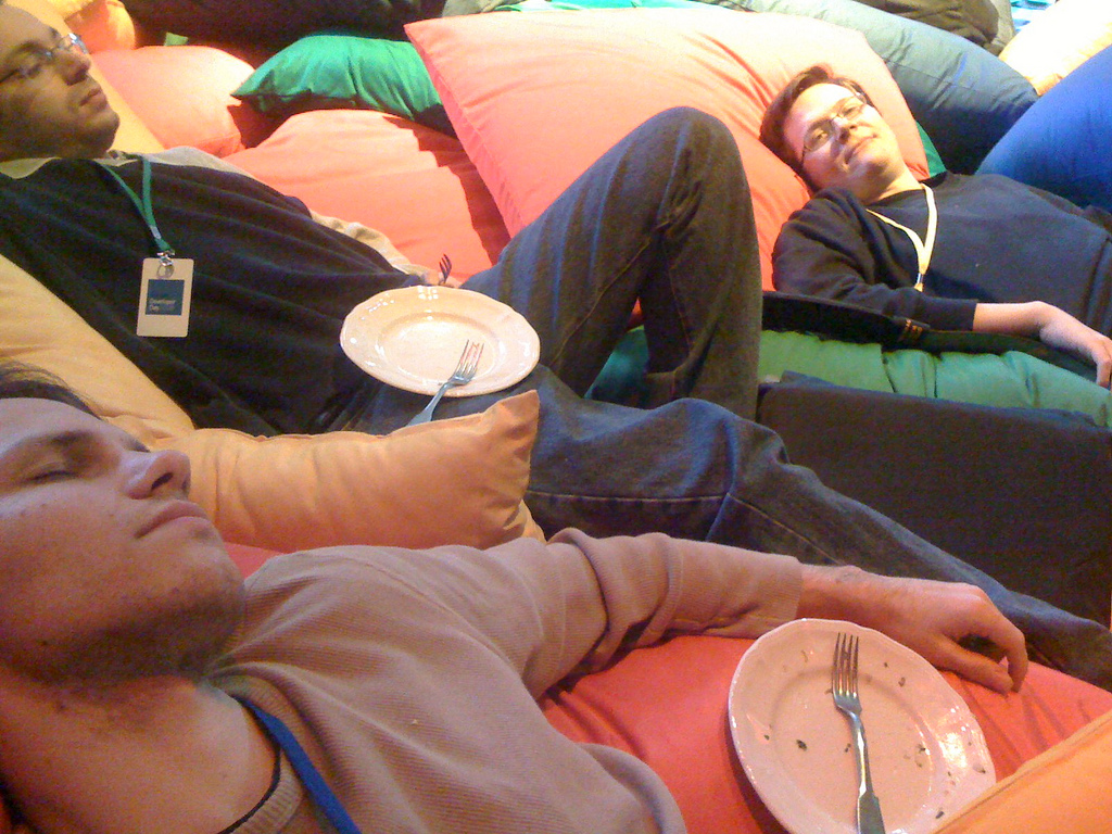 white space at events: photograph of conference attendees relaxing on large pillows after a meal. Image attribution: Flickr user zavie.