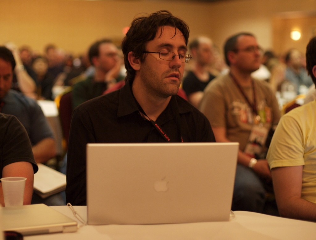breaks between meeting sessions: photograph of a tired conference attendee with his eyes closed. Photo attribution: Flickr user jarkko