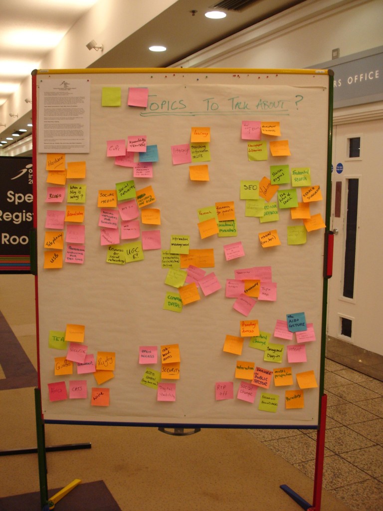 what attendees want to talk about: a photograph of a portable cork board covered with flipchart paper containing many different written sticky notes. Photo attribution: Flickr user edmittance