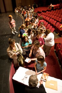self-publish your book: photograph of an author signing books for a line of readers