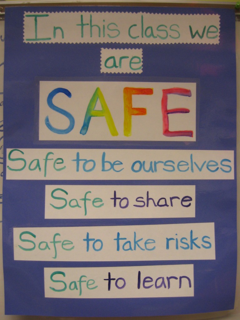 safe environment learning safety: a photograph of a handmade classroom poster that says "In this class we are SAFE. Safe to be ourselves. Safe to share. Safe to take risks. Safe to learn. Photo attribution: Flickr user willowpoppy