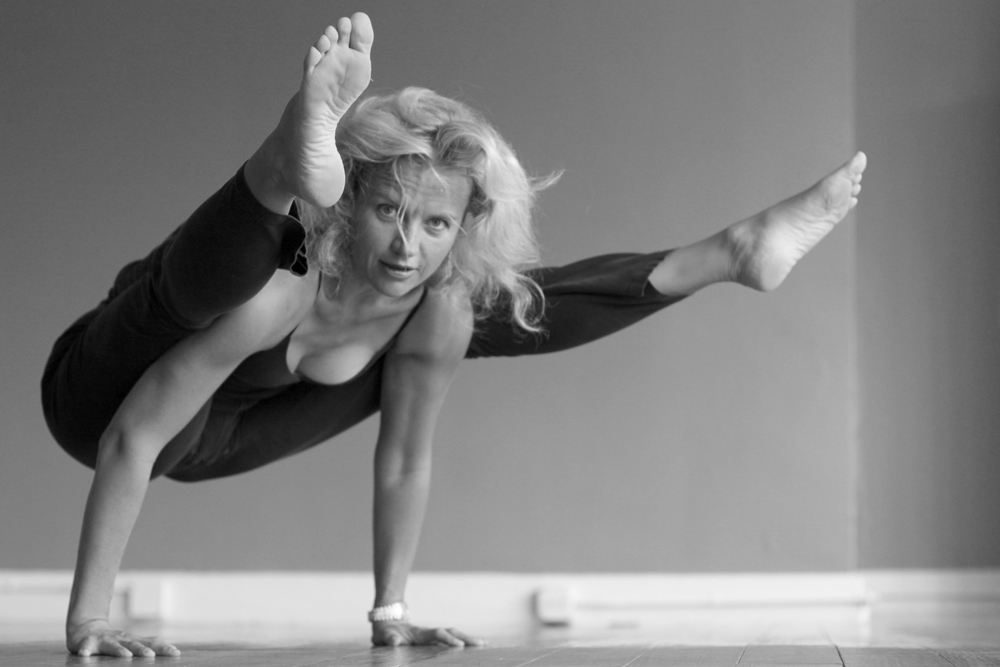 Conferences need to be flexible: Photograph of a woman gymnast dressed in black balancing on her hands with her body and legs parallel to the floor