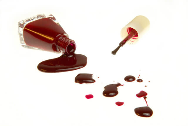 Cosmetic conferences: a photograph of a spilled bottle of red nail polish