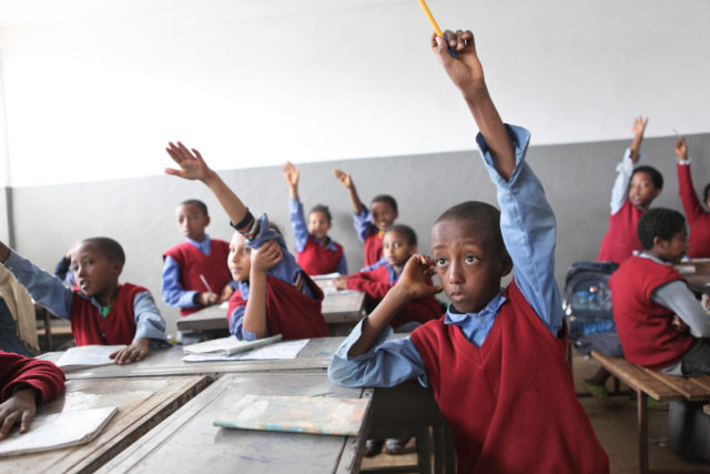 Public, semi-anonymous, and anonymous voting: a photograph of children raising their hands in a classroom. Photo attribution: Flickr user gpforeducation