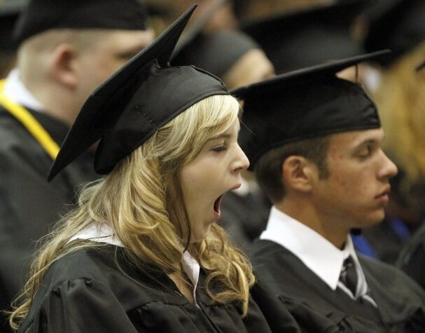 Rethink event formats! A graduating student, dressed in a cap and gown, sits and yawns. She is surrounded by other graduates.