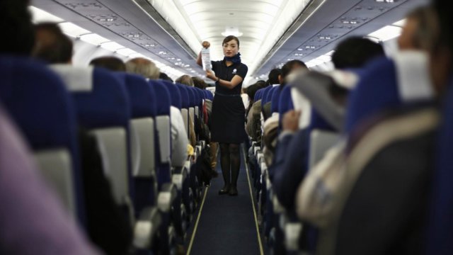 Photograph: An American Airlines flight attendant pitches a credit card on a full plane.