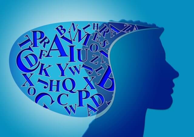 being present: An illustration in shades of blue of the silhouette of a person's head, with a melange of letters contained in a bubble behind them. Photo attribution: pixabay.com