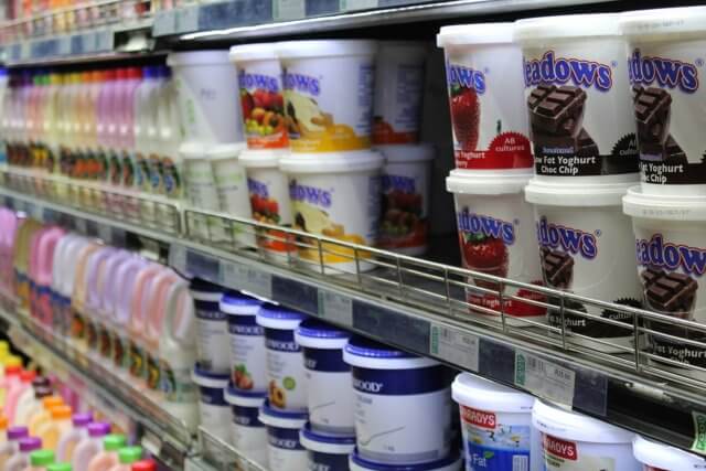 contains active cultures: a photograph of a row of supermarket shelves holding yogurts