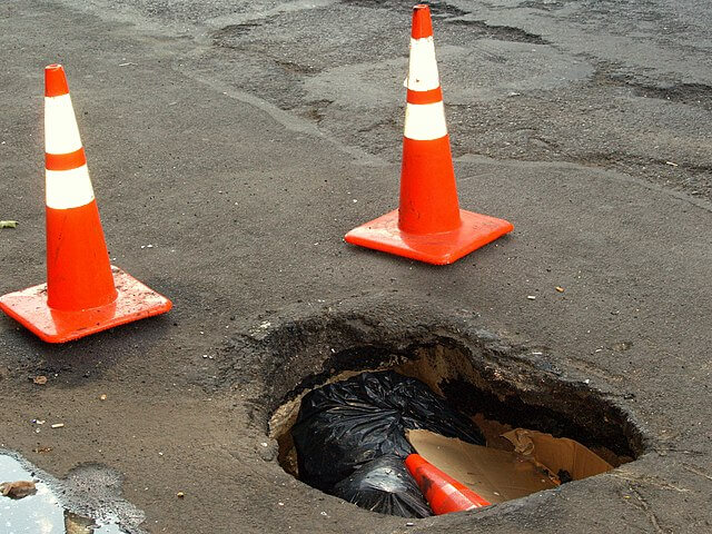 holes A large pot hole on Second Avenue in the East Village of New York City, deep enough to contain a traffic pylon and several bags of garbage. As of August 16, 2008, it had been there for around two weeks.