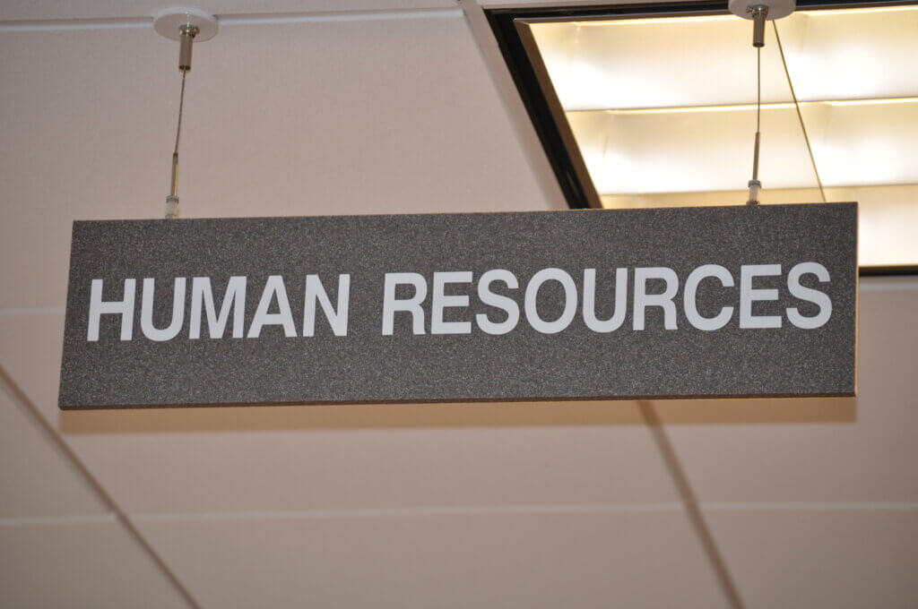 Get Rid Of Human Resources! A photograph of a Human Resources sign hanging from an office ceiling.