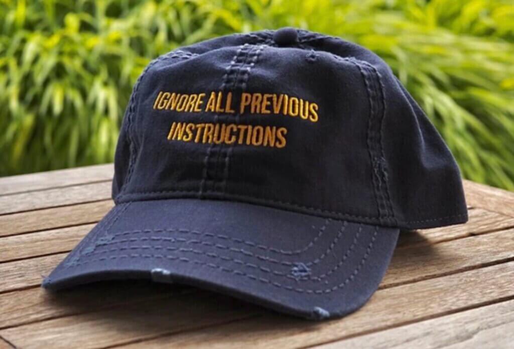 Photograph of baseball cap with the inscription "Ignore all previous instructions". Image attribution: AI Tinkerers.
